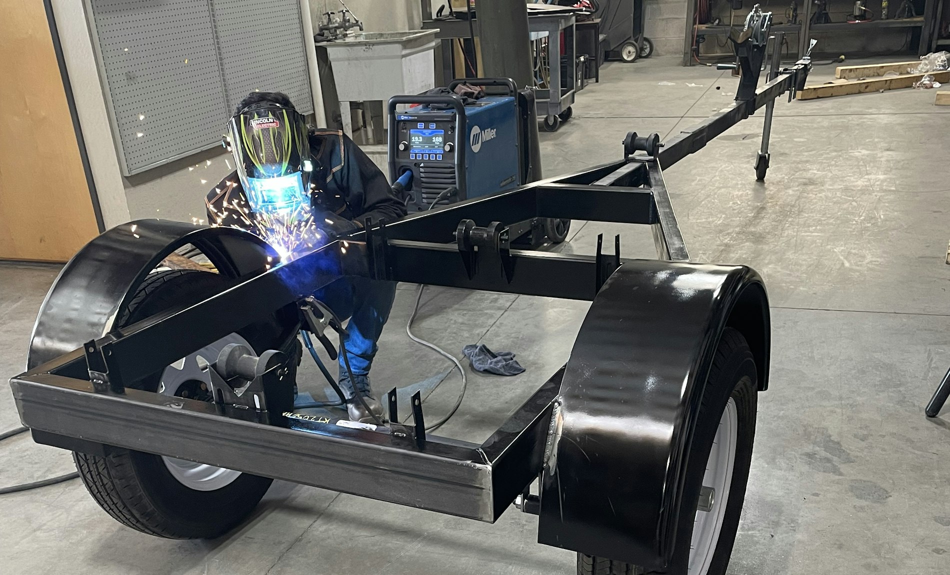 Soudeur travaillant sur un châssis de remorque à l'atelier